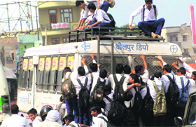 Schoolchildren hang precariously on a Haryana Roadways bus in Faridabad district, putting their lives at great risk.