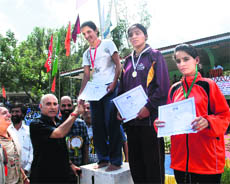 Public Works Department Minister Gulab Singh Thakur presents certificates to winners of a 1,500-m race in Mandi on Sunday.