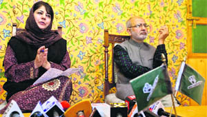 PDP president Mehbooba Mufti along with a party leader addresses a press conference in Srinagar on Sunday.
