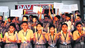 Students of DAV Public School offer prayers by lighting candles in Amritsar on the eve of the anniversary of the terror attack on the World Trade Center in the USA