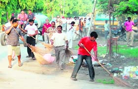 Workers of the Municipal Corporation clean a road during a special cleanliness drive in Amritsar on Monday