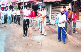 Workers of the Municipal Corporation clean a road during a special cleanliness drive in Amritsar on Monday