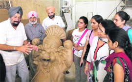 Proprietor of an arts factory talks to students of the Arts College of Punjabi University, Patiala, who visited the factory in Mohali on Monday.