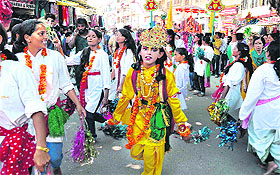 A girl dressed as Lord Krishna, along with other girls, dances to the tunes of hymns during a religious processsion in Haridwar.