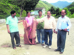 Members of the Parent-Teacher Association show the torn rug used by the students at Government Inter-College at Thatyur in Tehri Garhwal 