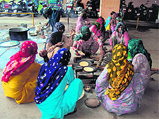 Dalit women belonging to families that have been squatting outside the mini-secretariat in Hisar, cook meals in one of the buildings lawns.