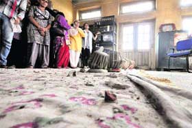 Teachers and students look at a part of the building which got damaged
