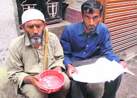 Fakir Hussain and his son Tufail Hussain seek alms in a Rajouri market