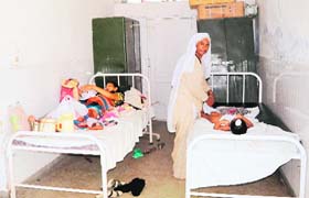 Patients lying on beds kept in the corridor at the Tarn Taran Civil Hospital