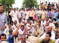 Residents of Kathura village stage a dharna in front of the Kathura power substation on Tuesday evening. A Tribune photograph