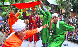 Artistes enact a scene from a play in Kulgam on Tuesday. 