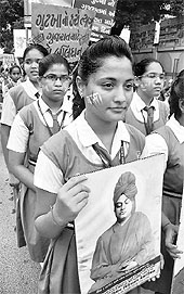A schoolgirl holds a portrait of Swami Vivekananda at a rally against gutkha and tobacco products in Ahmedabad on Tuesday.