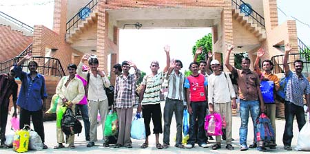Indian prisoners wave as they arrive through Wagah border on Tuesday after their release by Pakistan.