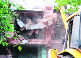 JCB machines demolish shops near the Durgiana temple complex as part of the land acquisition drive in Amritsar on Wednesday