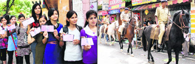 Students wait for their turn to cast votes in the DAV (PG) College elections in Dehradun on Wednesday; and (right) mounted police keeps a vigil outside the college. 