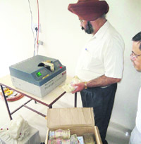 An official counts the money seized by the police at the Dehradun SSPs office on Wednesday. 