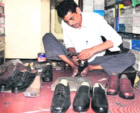 A shoemaker makes a footwear at his shop in Amritsar on Thursday