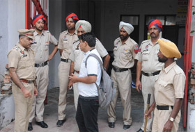 Policemen make enquiries at a house on Ajit Road on Thursday morning. 