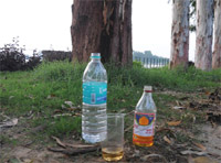 The bottle of liquor and water besides a glass that was found near the lake.