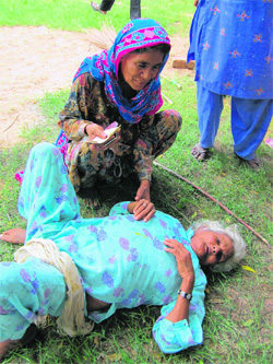 An elderly woman who fainted while standing in a queue for her pension at Bhuna in Fatehabad on Wednesday.