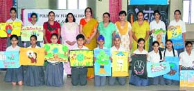 Participants of painting competition show their posters on environment at Police DAV College in Jalandhar on Thursday