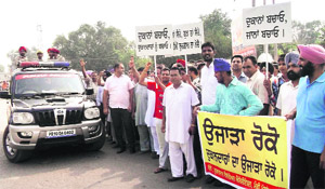 Shopkeepers stage a protest against a demolition drive at Mullanpur Dakha on Thursday. 