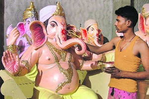 An artisan gives the finishing touches to an idol of Lord Ganesha at Kidwai Nagar.