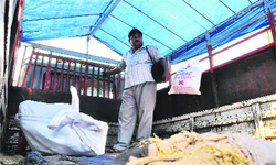 Ajay Kumar with the body (wrapped in white cloth) of his relative Davinder who was killed in the factory blast, in Khanna. Tribune photo: Himanshu Mahajan