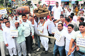 BJP activists hold aloft an LPG cylinder during a protest against the hike in the prices of diesel and domestic gas in Karnal on Friday. 
