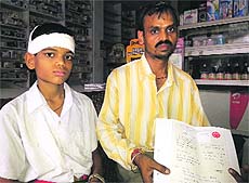 Injured student Daman and his father Shiv Charan show the hospital record in Ludhiana on Friday.