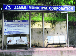 A man rests on a bench at a passenger shed in Jammu on Saturday.