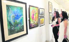 Visitors take a look at paintings during an exhibiton at the Virsa Vihar in Jalandhar on Saturday. Tribune photo: Malkiat Singh