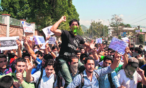 Students hold placards and raise anti-US slogans to protest against the controversial film, Innocence of Muslims, in Srinagar on Saturday.