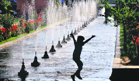 A boy enjoys in the Mughal Garden in Srinagar.