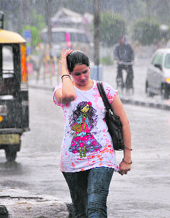 A girl walks on as heavy showers lash Ludhiana on Saturday.