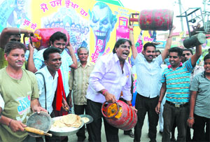 Former municipal councillor Vijay Kumar stages protest in Paras Ram Nagar against the quota fixed for subsidised LPG cylinders on Sunday. A huge flexboard listed the alleged scams that have taken place under the UPA government.