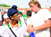 Jose Rubin Statham of New Zealand signs on the T-shirt of a young boy