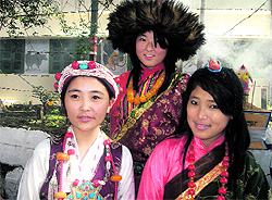 School students dressed in traditonal attire wait for the Dalai Lama