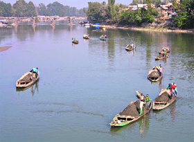 Scooping out livelihood: People collect sand from the Jhelum bed in Baramulla.