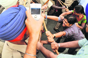  Policemen try to stop teachers from blocking the Ludhiana-Chandigarh road in Ludhiana on Sunday. 