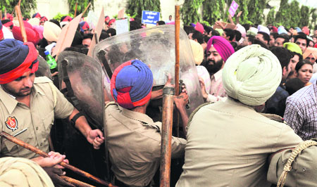 Policemen try to stop teachers from blocking the Ludhiana-Chandigarh road in Ludhiana on Sunday