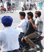 Wearing a helmet is compulsory for two-wheeler riders but there are violations galore in smaller towns. Tribune file photo