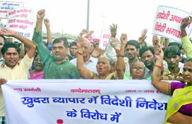 Workers of the Swadeshi Jagran Manch shout anti-UPA government slogans during a demonstration against the FDI in retail near the Seelampur Metro station in New Delhi on Monday