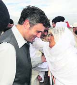 An elderly woman pilgrim hugs CM Omar Abdullah at the Srinagar airport.