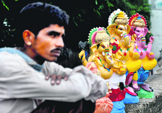  A man waits for customers to sell idols of Lord Ganesha ahead of Ganesh Chaturthi in Jammu.