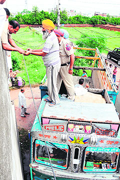 A police team inspects an electricity wire, which came in contact with a truck, at Ranjit Vihar in Amritsar on Tuesday.