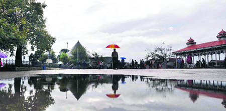 People walk with their umbrellas in Shimla on Tuesday. 
