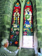 Prem David, secretary, St Johns Church, points towards damaged Belgian stained-glass windows, donated by Lady Elgin.