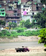 A tractor trolley collects gravel from the Tawi riverbed in Jammu.
