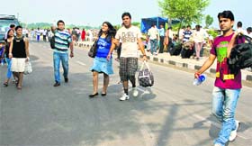Tourists take a walk on the Boulevard Road near Dal Lake in Srinagar on Tuesday.
